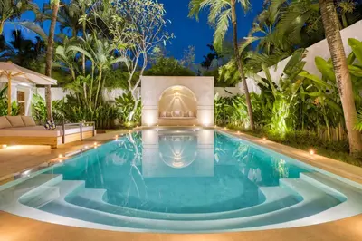 a swimming pool in the middle of a backyard with palm trees at Villa Chandika - 4 BDR Villa with private Pool, walk to the beach in Seminyak