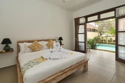 a bedroom with a large bed with a large window at CASA BEGJA I Tranquil 2BR Villa w Private Pool in Mertanadi in Seminyak