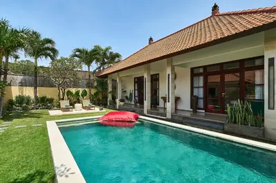 a swimming pool in front of a house at CASA BEGJA I Tranquil 2BR Villa w Private Pool in Mertanadi in Seminyak