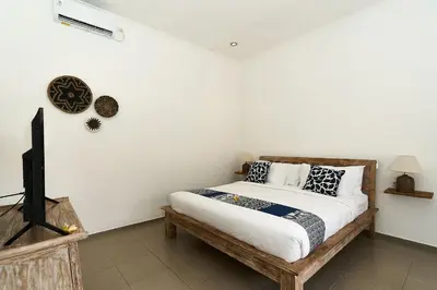 a bedroom with a bed and a flat screen tv at CASA BEGJA I Tranquil 2BR Villa w Private Pool in Mertanadi in Seminyak