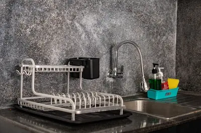 a kitchen sink with a dish drying rack on it at Casa Jinah 1 I Simply Modern Twin Villas (2BR) with Private Pool in Seminyak
