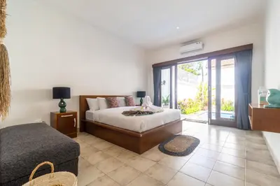 a bedroom with a bed and a sliding glass door at Casa Jinah 2 I Simply Modern Twin Villas (2BR) in Bidadari in Seminyak