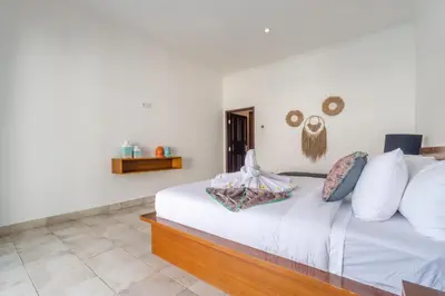 a bedroom with a bed with white sheets and pillows at Casa Jinah 2 I Simply Modern Twin Villas (2BR) in Bidadari in Seminyak