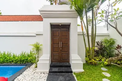a wooden door in a house with a swimming pool at Casa Jinah 2 I Simply Modern Twin Villas (2BR) in Bidadari in Seminyak