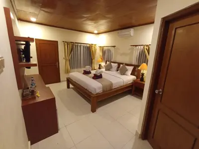 a bedroom with a bed in a room with curtains at Kusnadi Hotel in Legian