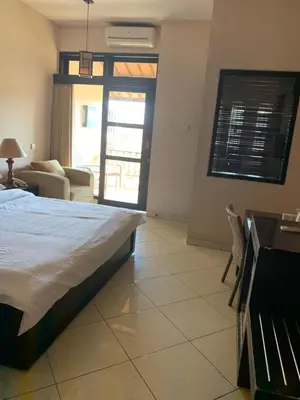 a bedroom with a bed and a living room at Fat Yogi Cottages in Kuta