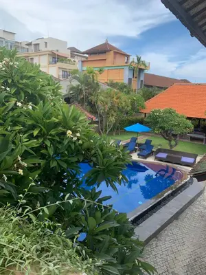 a view of a swimming pool with trees and buildings at Fat Yogi Cottages in Kuta