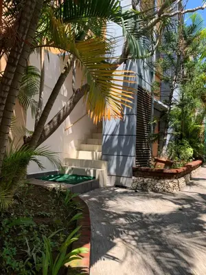 a courtyard with palm trees and a building at Fat Yogi Cottages in Kuta