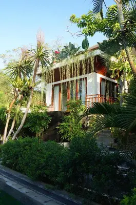 a house with palm trees in front of it at Aqua Octaviana Bali Villa in Canggu