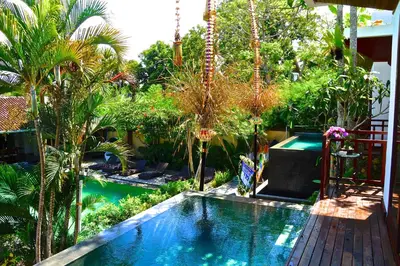 a swimming pool in the middle of a garden at Aqua Octaviana Bali Villa in Canggu