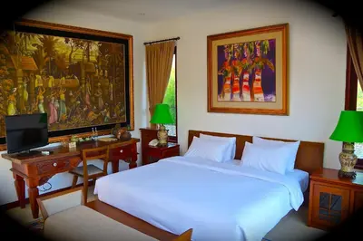 a bedroom with a bed and a desk with a computer at Aqua Octaviana Bali Villa in Canggu