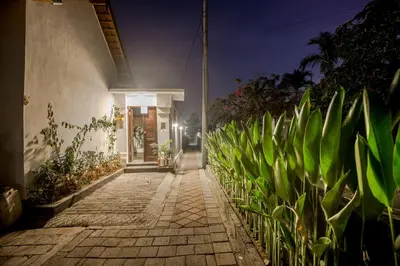 a cobblestone walkway in front of a house at night at Villa Lemone by Bali Villa Solutions in Seminyak