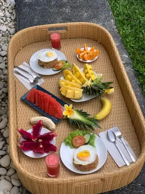 a tray of breakfast food with eggs and fruit at Villa Deba 2 by Bali Villa Solutions in Seminyak