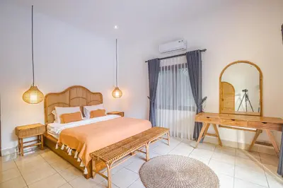 a bedroom with a bed and a table and a mirror at Villa Deba 2 by Bali Villa Solutions in Seminyak