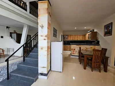 a kitchen and dining room with a refrigerator and a table at Tegalsari Guest House Canggu in Canggu