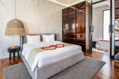 a bedroom with a large white bed and a bath tub at Villa Giraffe Seminyak, 4br short walk to Potato Head in Seminyak
