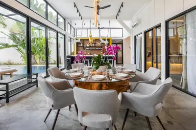 a dining room with a wooden table and chairs at Villa Giraffe Seminyak, 4br short walk to Potato Head in Seminyak