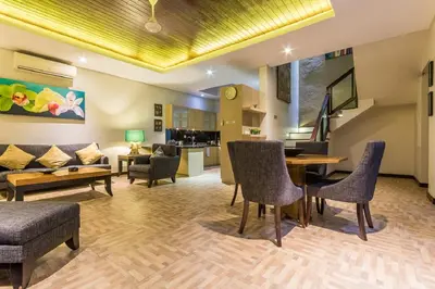 a living room with a couch and a table and chairs at Villa Lisha in Canggu