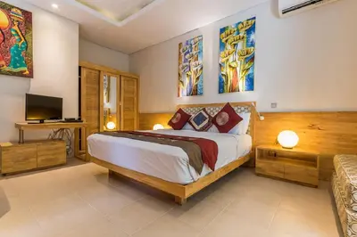 a bedroom with a large bed and a television at Villa Lisha in Canggu