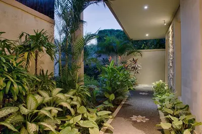 an indoor garden with plants and a building at Villa Lisha in Canggu