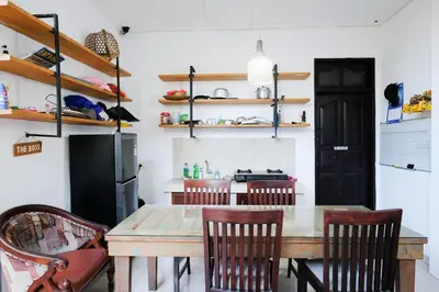 a dining room with a wooden table and chairs at RedDoorz at Serenity Inn Teuku Umar Denpasar in Denpasar