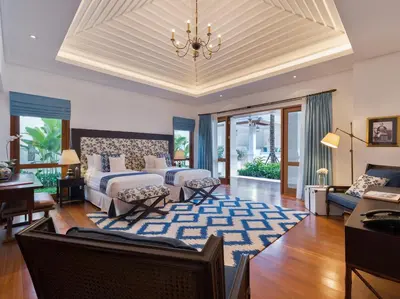a bedroom with two beds and a living room at Villa Windu Asri in Seminyak
