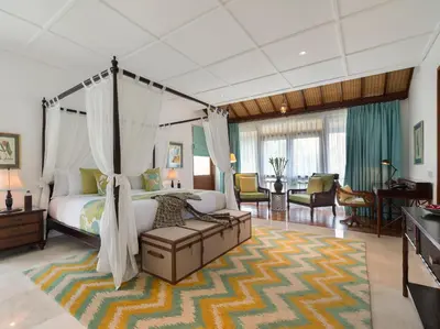 a bedroom with a canopy bed and a living room at Villa Windu Asri in Seminyak