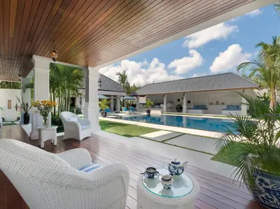 an outdoor patio with a pool and a house at Villa Windu Asri in Seminyak