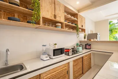 a kitchen with wooden cabinets and a microwave at ☆ Villa Larissa ☆ Seminyak 2BR Pool Kuta Petitenget in Seminyak