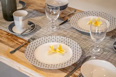 a table with plates and glasses on a wooden table at ☆ Villa Larissa ☆ Seminyak 2BR Pool Kuta Petitenget in Seminyak