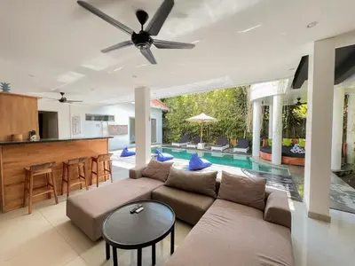 a living room with a couch and a table at 3BR Del Mar Beach Villas Near La Plancha Seminyak in Seminyak