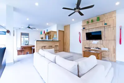 a living room with a white couch and a ceiling fan at 3BR Del Mar Beach Villas Near La Plancha Seminyak in Seminyak