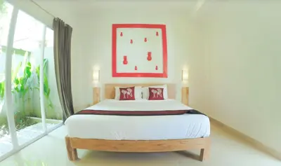 a bedroom with a bed with a clock on the wall at 3BR Del Mar Beach Villas Near La Plancha Seminyak in Seminyak