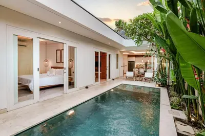 an indoor pool in a villa with a bedroom at Villa Vana, Sitara Villa Group in Seminyak