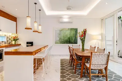 a kitchen and dining room with a wooden table and chairs at Villa Vana, Sitara Villa Group in Seminyak