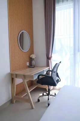 a bedroom with a desk and a chair and a mirror at Olivia SOHO Guest House in Legian