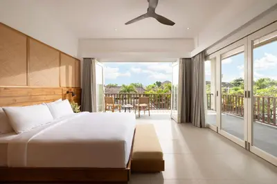 a bedroom with a bed and a balcony at Villa Christie By Nakula in Seminyak