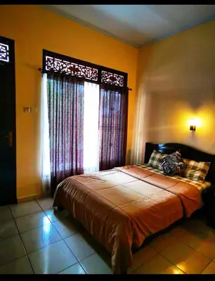 a bedroom with a large bed with a window at Celebbest in Kuta