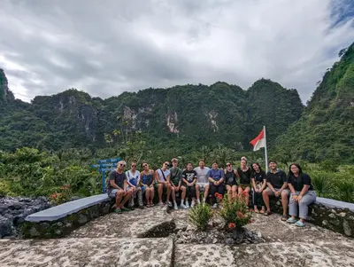 a group of people posing for a picture in front of mountains at Celebbest in Kuta