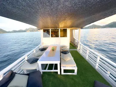 a boat with a table and chairs on the water at Celebbest in Kuta