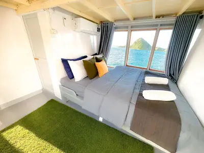 a bed in a small room with a view of the ocean at Celebbest in Kuta