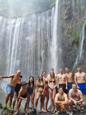 a group of people standing in front of a waterfall at Celebbest in Kuta