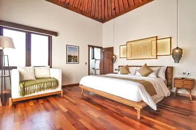 a bedroom with a large bed and a couch at Villa Kalita Bali in Seminyak