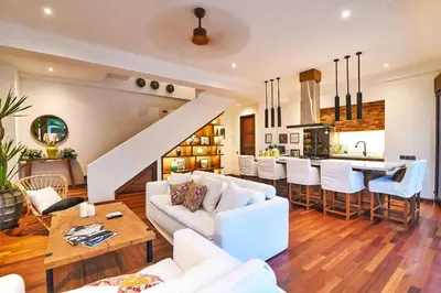a living room with white furniture and a kitchen at Villa Kalita Bali in Seminyak