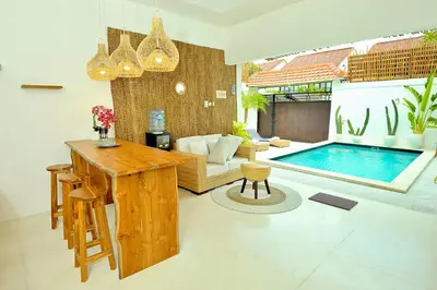 a living room with a table and a swimming pool at Villa Elijah in Seminyak
