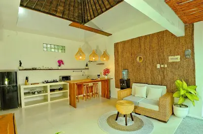 a living room with a couch and a table and a kitchen at Villa Elijah in Seminyak