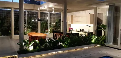 a patio with a table and benches in a building at Villa Mandja - Stunning architect-designed 3BR villa in Petitenget in Seminyak