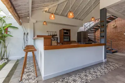 a kitchen with a white counter and a stool at Villa Madura DREAM 3bdrs Central Seminyak in Seminyak