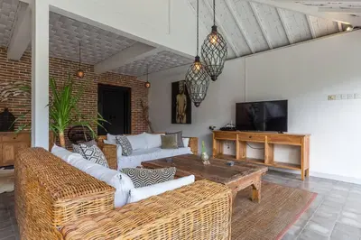 a living room with couches and a table and a tv at Villa Madura DREAM 3bdrs Central Seminyak in Seminyak