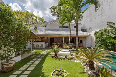 a courtyard of a house with a pool and palm trees at Villa Madura DREAM 3bdrs Central Seminyak in Seminyak